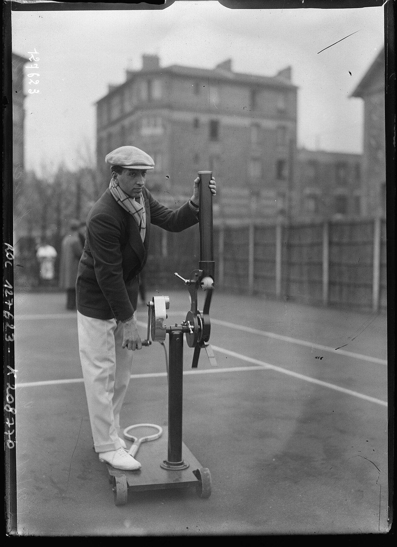 René Lacoste with an early ball-throwing machine on a tennis court, 1928